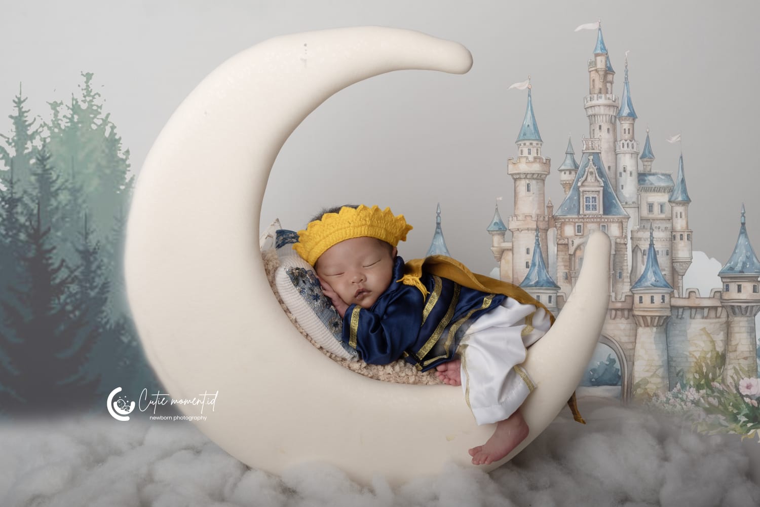Foto bayi baru lahir dengan kostum pangeran tidur di atas properti bulan sabit